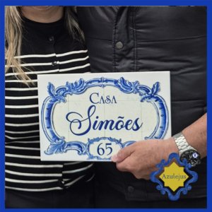 Casal a segurar azulejo com o texto Casa Simões.